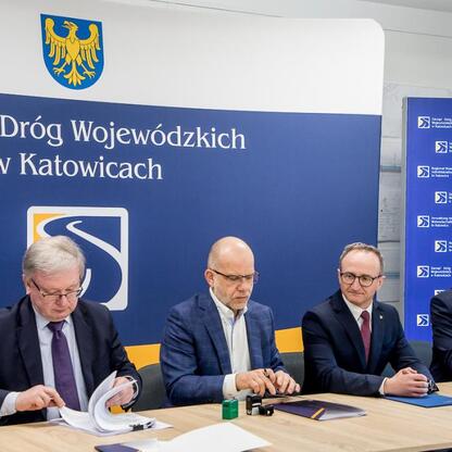 Wicemarszałek Grzegorz Boski wraz z uczestnikami konferencji prasowej przedstawia inwestycję w przebudowę DW 492. (wygenerowano przez AI)