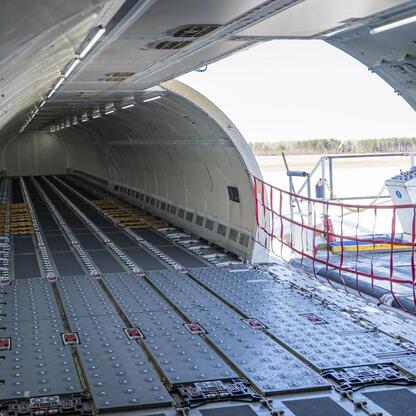 Wnętrze Airbusa A321F, przystosowane do przewozu 28 ton ładunku, z widocznymi metalowymi panelami podłogowymi i otwartymi drzwiami do ładunku. (wygenerowano przez AI)