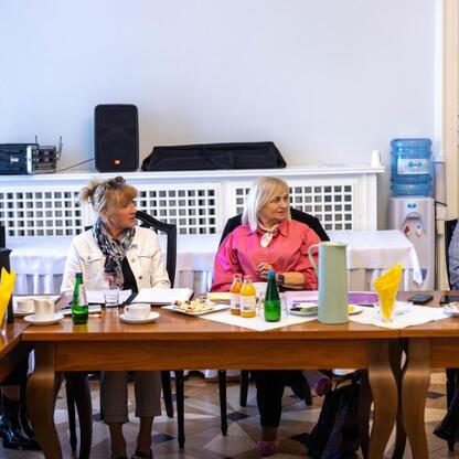 Grupa kobiet w Gmachu Sejmu Śląskiego podczas spotkania jubileuszowego Uniwersytetów Trzeciego Wieku. (wygenerowano przez AI)