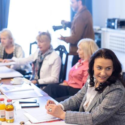 Grupa ludzi w spotkaniu jubileuszowym Uniwersytetu Trzeciego Wieku w Gmachu Sejmu Śląskiego. (wygenerowano przez AI)