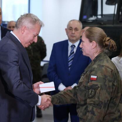 Wojciech Saługa i Leszek Pietraszek podczas ceremonii wręczenia certyfikatu województwu obrony terytorialnej w Katowicach. (wygenerowano przez AI)