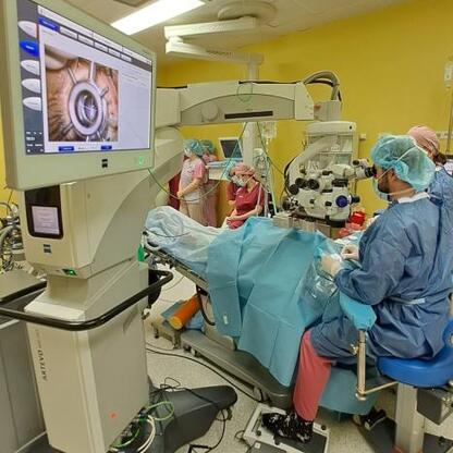Zdjęcie przedstawia szpitalny salę operacyjną, gdzie lekarze wykonują nowatorską operację oczu, wykorzystując zaawansowane technologie laserowe. (wygenerowano przez AI)