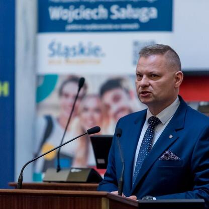 Członek Zarządu Województwa Śląskiego Rafał Adamczyk przemawia na konferencji o bezpieczeństwie dzieci w sieci. (wygenerowano przez AI)