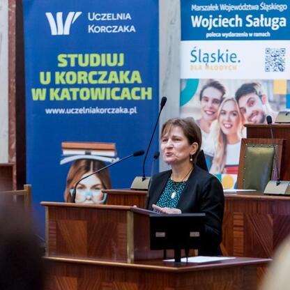 Podczas konferencji w Korczak University w Katowicach, uczestniczka wygłasza przemówienie na temat bezpieczeństwa dzieci w sieci. (wygenerowano przez AI)