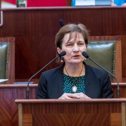 Kobieta przemawia na podium w konferencji o bezpieczeństwie dzieci w sieci. (wygenerowano przez AI)