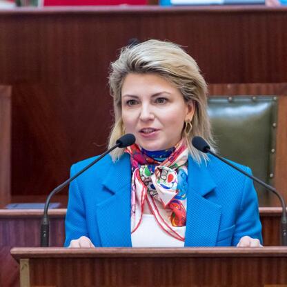 Kobieta przemawia na podium w konferencji o bezpieczeństwie dzieci w sieci. (wygenerowano przez AI)