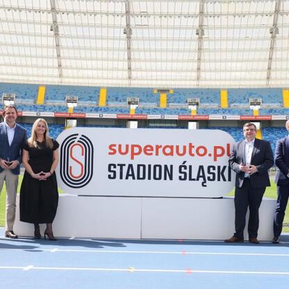 Grupa osób z Superauto.pl i Stadion Śląski podpisuje umowę o współpracy wokół bieżni Kotła Czarownic. (wygenerowano przez AI)