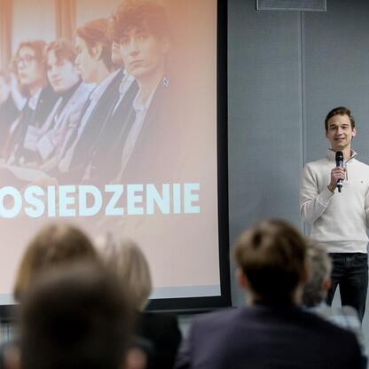 II Sesja Rady Młodzieżowej na Stadionie Śląskim, młodzi mówią do mikrofonu. (wygenerowano przez AI)