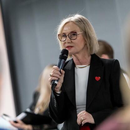 Na zdjęciu widoczna jest Joanna Bojczuk, członek Zarządu Województwa Śląskiego, przemawiająca na panelu w Silesia Stadium. (wygenerowano przez AI)