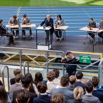 Panel dyskusyjny na Stadionie Śląskim, przedstawiciele województwa i parlamentu dyskutują z młodzieżą. (wygenerowano przez AI)
