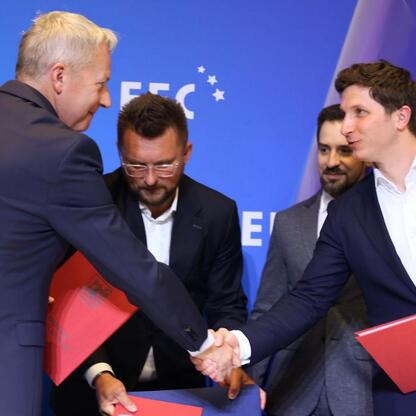 Trzy osoby w formalnym stroju podpisują list intencji, otwierającą rozwój przestrzeni kosmicznej w regionie Śląskim. (wygenerowano przez AI)