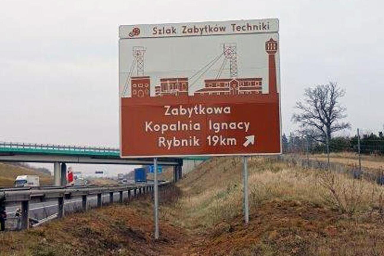Znak drogowy wskazujący na Zabytkową Kolej Wąskotorową w Rudach. (wygenerowano przez AI)