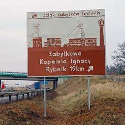 Znak drogowy wskazujący na Zabytkową Kolej Wąskotorową w Rudach. (wygenerowano przez AI)