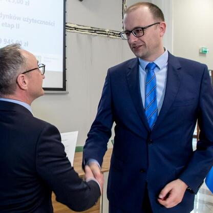 Grzegorz Boski, wicemarszałek Województwa Śląskiego, wręcza gratulacje beneficjentom projektów dofinansowanych z funduszy europejskich. (wygenerowano przez AI)