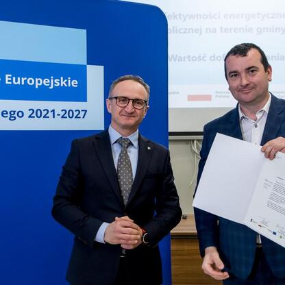 Wicemarszałek Województwa Śląskiego Grzegorz Boski wręcza dokumenty podczas uroczystości związanych z Europejskimi Funduszami dla Śląska 2021-2027. (wygenerowano przez AI)