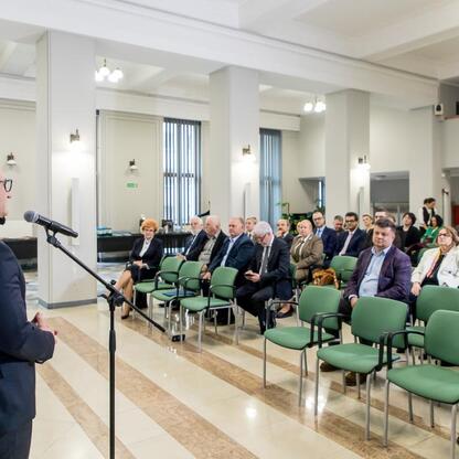 Wicemarszałek Województwa Śląskiego Grzegorz Boski przemawia na konferencji w Urzędzie Marszałkowskim, odbierając gratulacje za przyznane fundusze unijne. (wygenerowano przez AI)