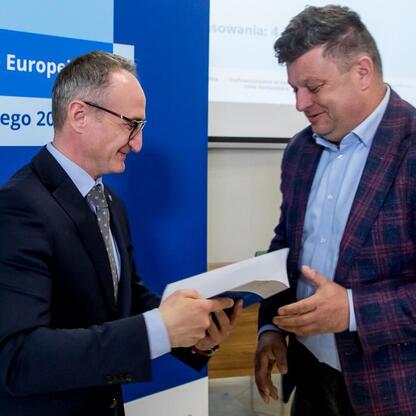 Grzegorz Boski, wicemarszałek Województwa Śląskiego, wręcza dokumenty uczestnikom projektów z Europejskich Funduszy dla Śląska. (wygenerowano przez AI)