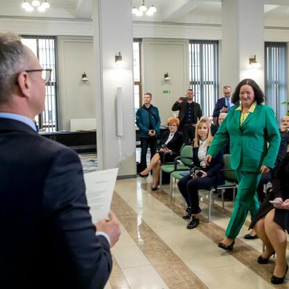 Formalna uroczystość w Słonecznym Sali, gdzie wojewoda Grzegorz Boski wręcza listy gratulacyjne beneficjentom projektów unijnych. (wygenerowano przez AI)