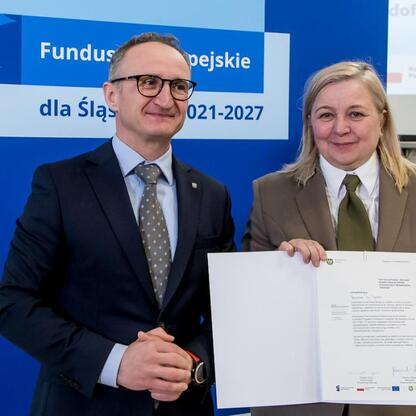 Grzegorz Boski i partnerka, wicemarszałek Województwa Śląskiego, prezentują certyfikaty z programu Fundusze Europejskie dla Śląska 2021-2027. (wygenerowano przez AI)