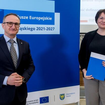 Wicemarszałek Województwa Śląskiego Grzegorz Boski wręcza listy gratulacyjne beneficjentom projektów dofinansowanych z Europejskich Funduszy dla Śląska 2021-2027. (wygenerowano przez AI)