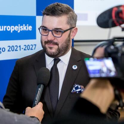 Wojewódzki wicemarszałek Grzegorz Boski podczas konferencji prasowej o projekcie Funduszy Europejskich dla Śląska 2021-2027. (wygenerowano przez AI)