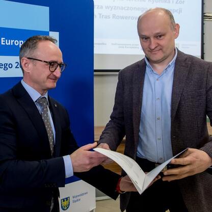 Grzegorz Boski, wicemarszałek Województwa Śląskiego, wręcza list gratulacyjny beneficjentom funduszy europejskich. (wygenerowano przez AI)