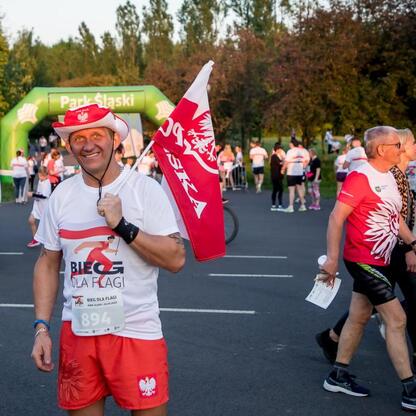 Bieg dla Flagi 2025, Park Śląski, uczestnik z flagą Polski, meta na Kotle Czarownic. (wygenerowano przez AI)