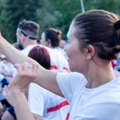 Na Biegu dla Flagi 2025 w Parku Śląskim uczestniczka w białej koszulce robi selfie. (wygenerowano przez AI)