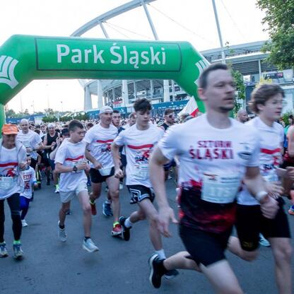 Bieg dla Flagi 2025 w Parku Śląskim, uczestnicy w białych koszulkach z czerwonymi i czarnymi akcentami. (wygenerowano przez AI)