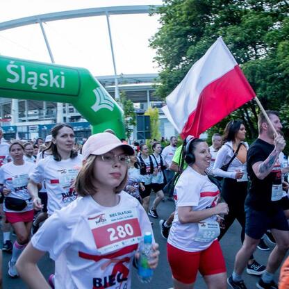 Bieg dla Flagi 2025 w Parku Śląskim - uczestnicy biegu z flagą Polski. (wygenerowano przez AI)
