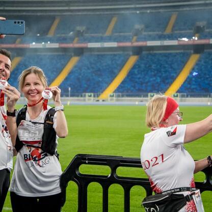 Zakończenie biegu dla Flagi 2025 w Parku Śląskim, uczestnicy w białych koszulkach z medalami. (wygenerowano przez AI)