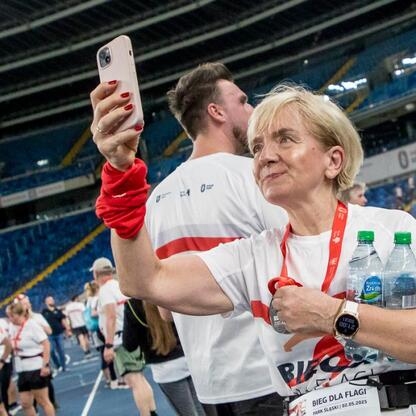 Bieg dla Flagi 2025, Park Śląski, uczestnicy w białych koszulkach, selfie, medal, atmosfera patriotyczna. (wygenerowano przez AI)