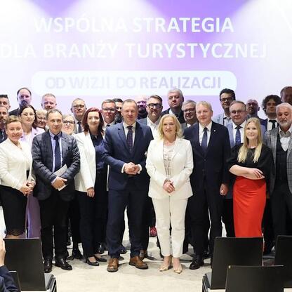 Wojciech Saługa, Marszałek Województwa Śląskiego, oraz Joanna Bojczuk, Członkini Zarządu Województwa, uczestniczą w konferencji o strategii turystycznej. (wygenerowano przez AI)