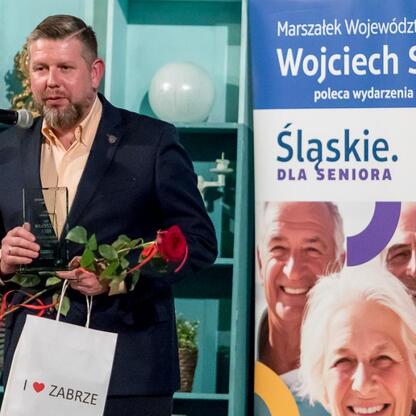 Wojciech Saługa, marszałek Śląskiego, wręcza nagrody na konkursie dla seniorów w Teatrze Nowym w Zabrzu. (wygenerowano przez AI)