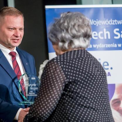 Członek Zarządu Województwa Śląskiego Rafał Adamczyk wręcza nagrodę na galę 
