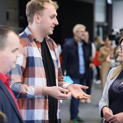 Grupa ludzi dyskutuje o aplikacji do funduszy unijnych w Arenie Zabrze. (wygenerowano przez AI)