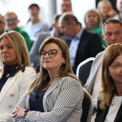 Zajęci uczestnicy konferencji w Nowym Zabrzu słuchają prezentacji o funduszach europejskich dla małych i średnich przedsiębiorstw. (wygenerowano przez AI)