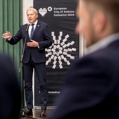 Marszałek Wojciech Saługa przemawia na podium podczas Forum Przyszłości Miasta Nauki w Katowicach. (wygenerowano przez AI)