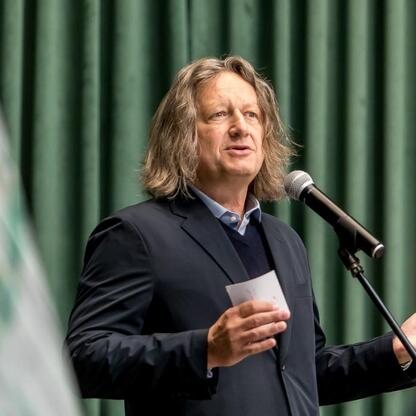 Podczas wydarzenia w Uniwersytecie Śląskim marszałek Wojciech Saługa przemawia na podium, podkreślając rolę nauki w transformacji regionu. (wygenerowano przez AI)