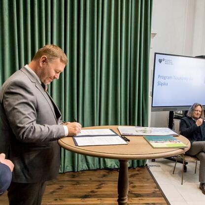 Podpis: Wojciech Saługa, Marszałek Województwa Śląskiego, podpisuje dokument na Forum Przyszłości Miasta Nauki. (wygenerowano przez AI)