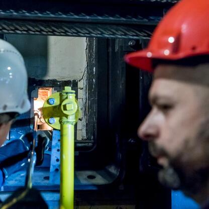 Dwa osoby w hard hatach inspektują nową baterię koksowniczą w Koksowni Przyjaźń w Dąbrowie Górniczej. (wygenerowano przez AI)