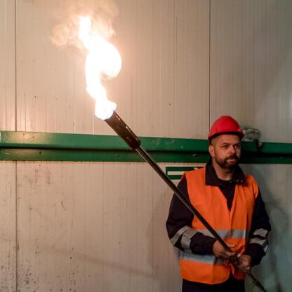 Pracownik w mundurze i ochronie przeprowadza test bezpieczeństwa w modernizowanej baterii koksowniczej JSW Koksownia Przyjaźń w Dąbrowie Górniczej. (wygenerowano przez AI)