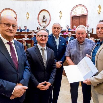 Grzegorz Boski, wicemarszałek Śląskiego Sejmiku, na ceremonii wręczenia dofinansowania dla 40 Rodzinnych Ogrodów Działkowych. (wygenerowano przez AI)