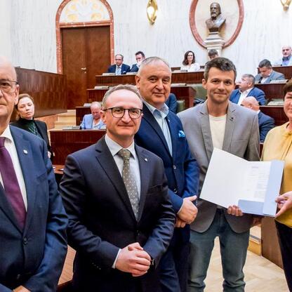Wicemarszałek Grzegorz Boski wręcza certyfikaty 40 rodzinom działkowym w Sali Sejmu Śląskiego. (wygenerowano przez AI)