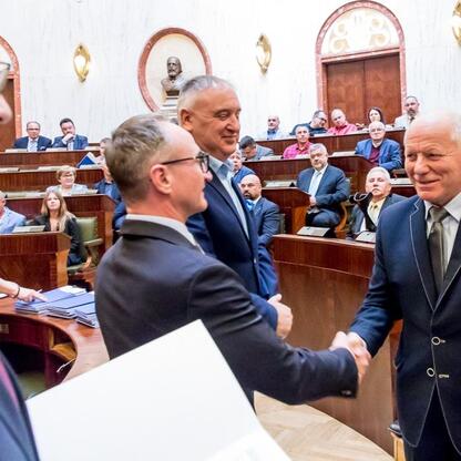 Wicemarszałek Grzegorz Boski i radni Marek Bieniek oraz Bronisław Karasek uczestniczą w uroczystości wręczenia umów w Sali Sejmu Śląskiego. (wygenerowano przez AI)