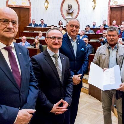 Wicemarszałek Grzegorz Boski wręcza certyfikaty 40 rodzinom działkowym w Sali Sejmu Śląskiego. (wygenerowano przez AI)