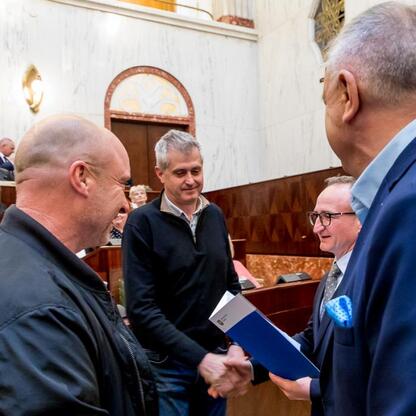 Wicemarszałek Grzegorz Boski wręcza dokument radnomu Marek Bieniekowi, podczas uroczystości w Sali Sejmu Śląskiego. (wygenerowano przez AI)