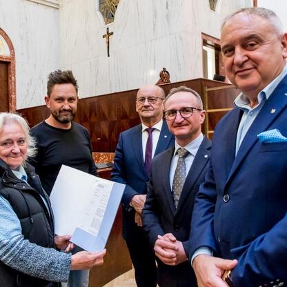 Wicemarszałek Grzegorz Boski wręcza certyfikaty laureatom grantu na 1,5 mln zł dla rodzinnych ogrodów działkowych. (wygenerowano przez AI)