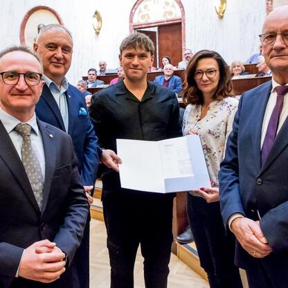 Wicemarszałek Grzegorz Boski wręcza umowy w Sali Sejmu Śląskiego. (wygenerowano przez AI)