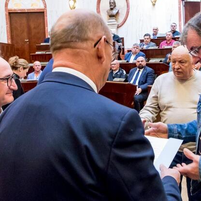 Wicemarszałek Grzegorz Boski prezentuje certyfikaty dofinansowania dla 40 rodzinnych ogrodów działkowych w Sali Sejmu Śląskiego. (wygenerowano przez AI)